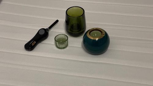 a green cup and a glass next to a wine opener at APARTHOTEL in Przemyśl