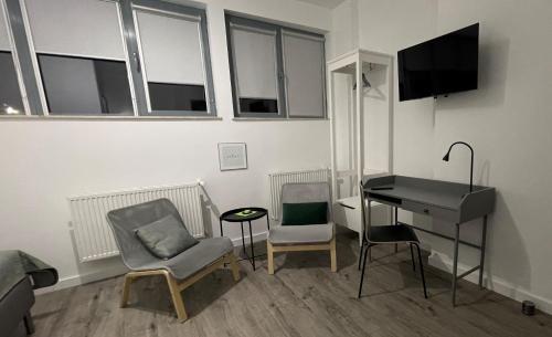 a living room with a desk and chairs and a table at APARTHOTEL in Przemyśl
