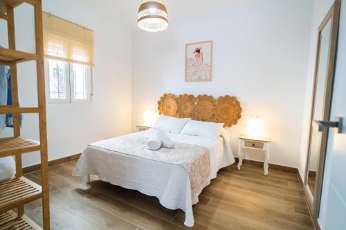 een slaapkamer met een groot bed met een houten hoofdeinde bij Apartamento Patio Real in Ronda