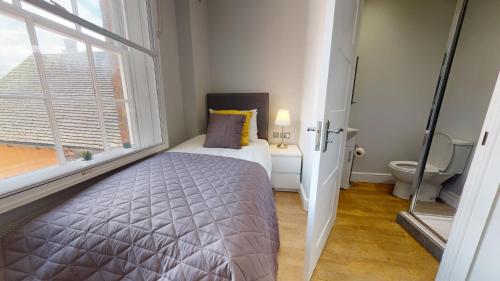 a bedroom with a bed and a large window at 1 Castle Yard in Coventry
