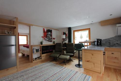 a kitchen with a counter and chairs in a room at Haus am Rain in Partenen