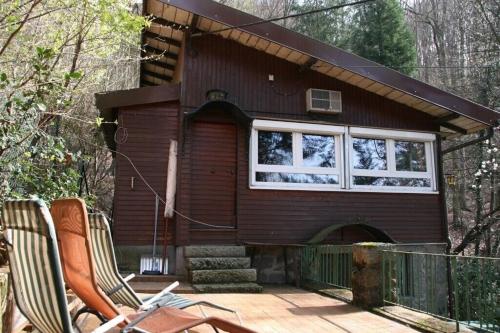 ein kleines Haus mit einer Terrasse und zwei Stühlen in der Unterkunft Vogesenblick in Offenburg