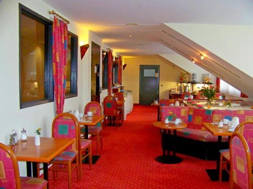 a restaurant with tables and chairs and a red carpet at Hotel Amadeus ROYAL Berlin in Berlin