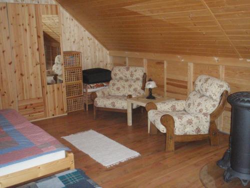 ein Wohnzimmer mit 2 Stühlen und einem Tisch in der Unterkunft Dubáčik Dovalovo in Liptovský Hrádok