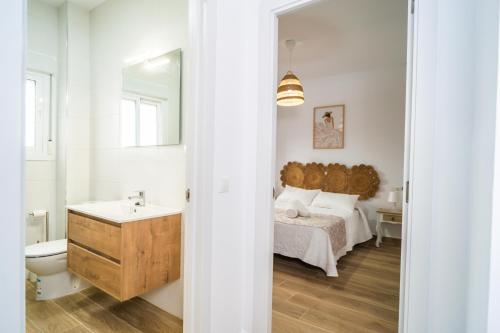 uma casa de banho com uma cama, um lavatório e um espelho. em Apartamento Patio Real em Ronda