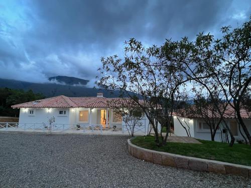 a white house with a mountain in the background at Victorias Villas in Villa de Leyva