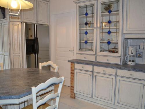 a kitchen with a table with chairs and a counter top at Gîte spacieux avec piscine privative, grand jardin et équipements bébé en Charente Limousine - FR-1-653-67 in Esse
