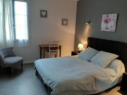 a bedroom with a bed and a chair and a window at Gîte spacieux avec piscine privative, grand jardin et équipements bébé en Charente Limousine - FR-1-653-67 in Esse