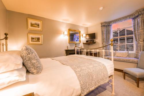 een slaapkamer met een bed, een stoel en een raam bij Waterwheel Guesthouse in Ambleside
