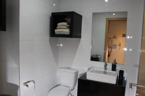W łazience znajduje się toaleta, umywalka i lustro. w obiekcie Charme Paraíso Sol w mieście Portimão