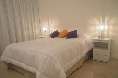 - une chambre avec un grand lit blanc et deux lampes dans l'établissement Green Park Exclusive Vacation, à Punta del Este