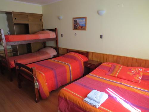 two beds in a room with two bunk beds at Palm Hostal in Iquique