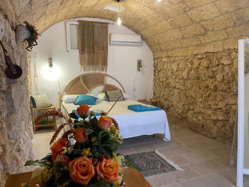 um quarto com uma cama numa parede de pedra em Fiorillo Cottage em Gagliano del Capo