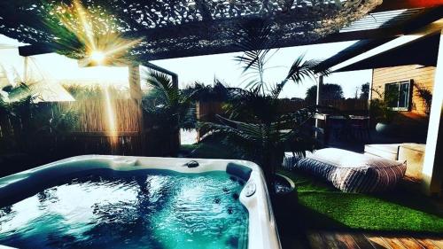 a bath tub in a yard with a pool of water at Zimmer spa in megadim in Bet Ẕevi