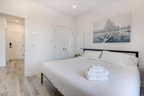 a bedroom with a large white bed with towels on it at M11 Upscale Spacious 1BR wKingBed AC in Heart of PlateauMile-End in Montréal