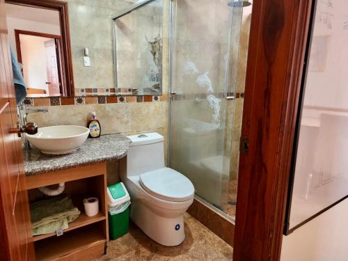 y baño con aseo, lavabo y ducha. en Quitumbe - Moderno y cómodo departamento, en Quito