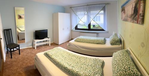 MönchhagenにあるFerienwohnung Schulz Mönchhagen - Erdgeschossのベッド2台とテレビが備わる客室です。