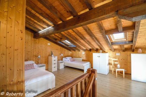 Artesoro Baserria في San Pedro de Galdames: غرفة نوم بسرير واريكة في غرفة بجدران خشبية
