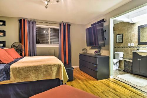 1 dormitorio con 1 cama y TV de pantalla plana en Suburban Detroit Home with Porch, Yard and Fire Pit! en Southfield