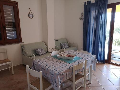 comedor con mesa, sillas y sofá en Tana della Volpe, en Arbus