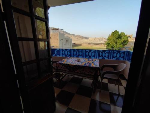 a table and a chair in a room with a window at Ahmed's House in Luxor