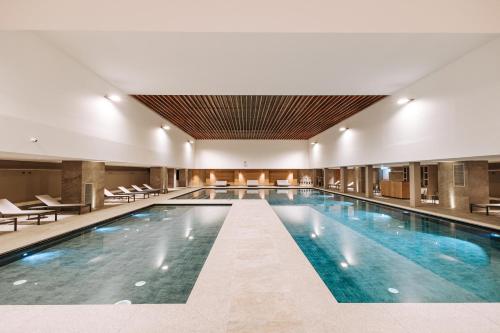 une grande piscine dans le hall de l'hôtel dans l'établissement Valtur Cervinia Cristallo Ski Resort, à Breuil-Cervinia