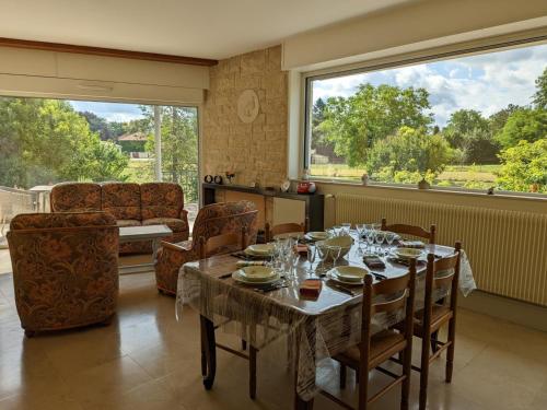 une salle à manger avec une table et des chaises et une grande fenêtre dans l'établissement Superbe maison avec spa privatif, jardin, animaux acceptés et Wi-Fi - FR-1-653-112, à Agris