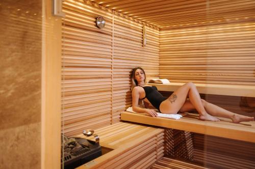 a woman is sitting in a sauna at Valtur Cervinia Cristallo Ski Resort in Breuil-Cervinia