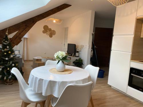 une cuisine et une salle à manger avec une table et un arbre de Noël dans l'établissement Chez Gustave charmant T2, 4 min place Ducale, à Charleville-Mézières