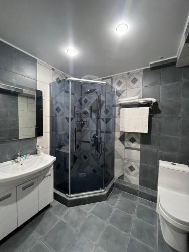 a bathroom with a shower and a sink and a toilet at Rooms Hotel Semey in Semey