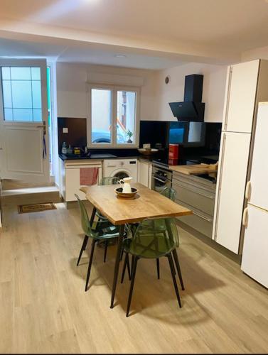 une cuisine avec une table en bois et des chaises vertes dans l'établissement L'AGACHON LA CIOTAT VIEUX PORT, à La Ciotat