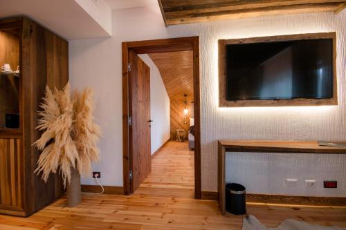 a living room with a flat screen tv on a wall at HANUL BUCOVINEI in Câmpulung Moldovenesc