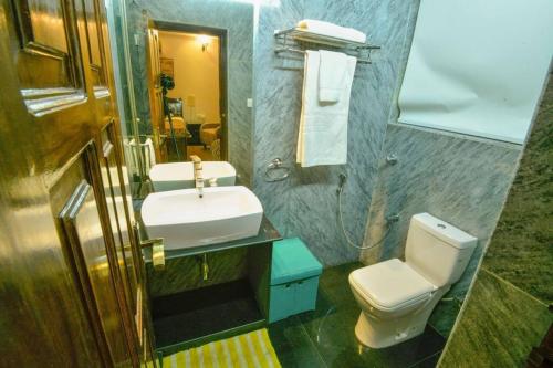 a bathroom with a sink and a toilet and a mirror at Villa Nazuri w Caretaker in Candolim