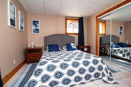 - une chambre avec un lit et une couette bleue et blanche dans l'établissement Villa Calypso avec vue sur la baie de Ste-Luce, à Sainte-Luce-sur-Mer