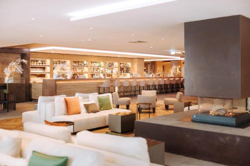 a lobby with white couches and a fireplace at Valtur Cervinia Cristallo Ski Resort in Breuil-Cervinia