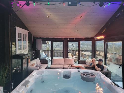 dos personas sentadas en una bañera en una casa en Ski In - Ski Out, Jacuzzi, Panorama View, en Geilo