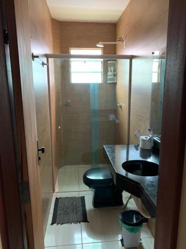 a bathroom with a shower with a toilet and a sink at Residência lençóis in Barreirinhas