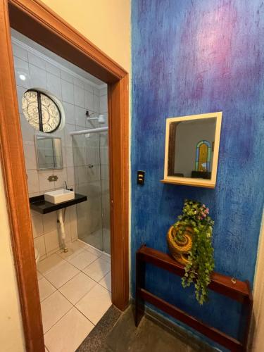 La salle de bains bleue est pourvue d'une douche et d'un miroir. dans l'établissement Casa Guilhermina com Piscina e Churrasqueira, à Praia Grande