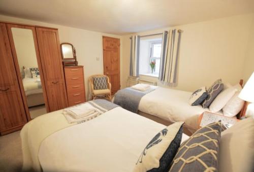 a hotel room with two beds and a window at Cliff Cottage in Gorran Haven