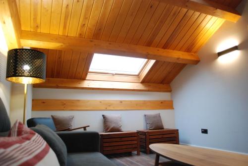 a living room with wooden ceilings and a window at Altar Suites Conde Luna by gaiarooms in León