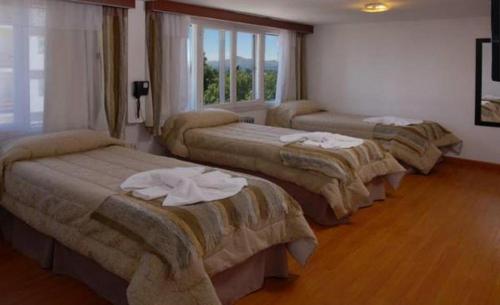3 camas alineadas en una habitación en Monte Cervino Hotel en San Carlos de Bariloche