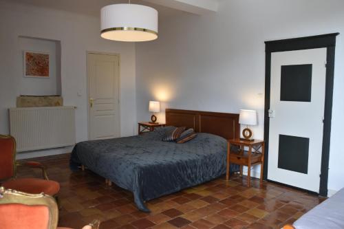 ein Schlafzimmer mit einem Bett, zwei Stühlen und einer Lampe in der Unterkunft Domaine de Bellevue Cottage en Périgord- Bergerac 5mn - Petits-déjeuners inclus - Salle d'eau privative - Parc 3ha - Parking Privé Gratuit in Lembras