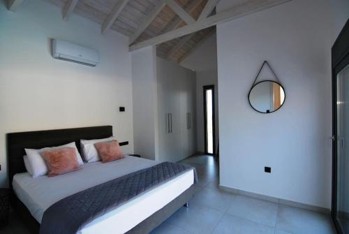 a bedroom with a large bed and a mirror at Villa Katerina Kefalonia in Kefallonia