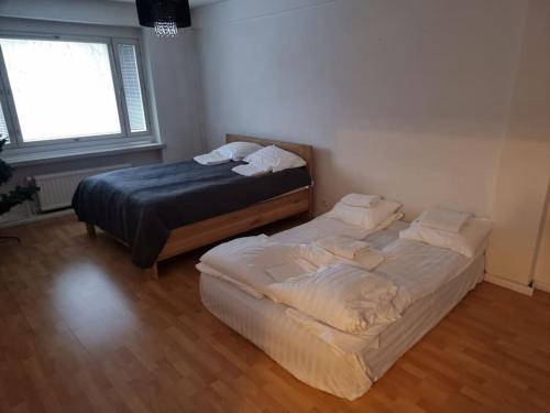 1 dormitorio con 2 camas y ventana en City home Kulmakartano en Jyväskylä