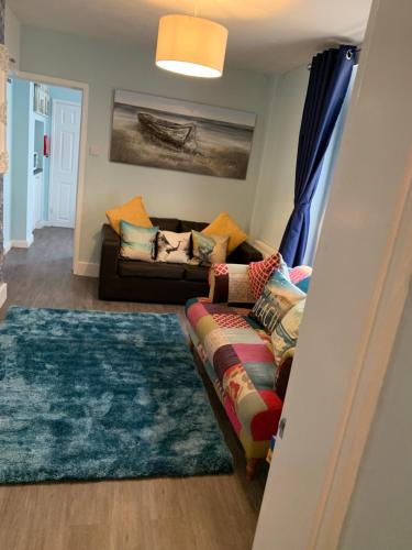 a living room with a couch and a rug at Ground Floor Apartment in Exmouth