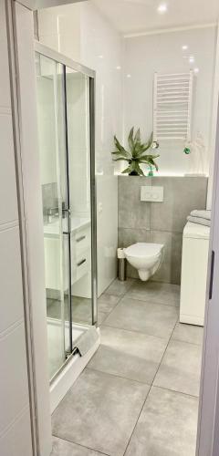 a white bathroom with a toilet and a sink at Exclusive Apartments Smolna in Warsaw