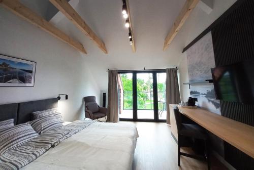 een slaapkamer met een bed, een bureau en een televisie bij Apartamenty Między Mostami in Stegna