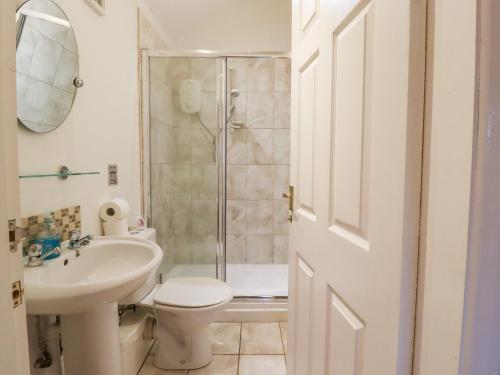 a bathroom with a toilet sink and a shower at Lair Close Cottage in Birstwith