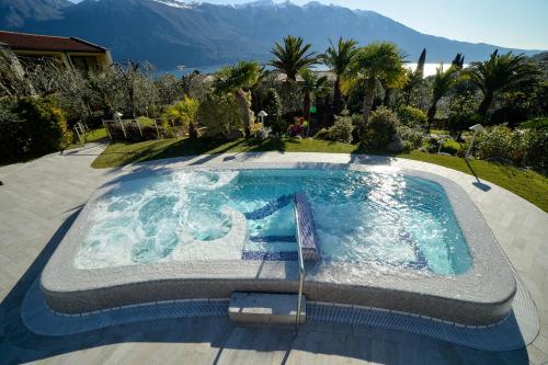 a large swimming pool in a yard with mountains in the background at Park Hotel Imperial in Limone sul Garda