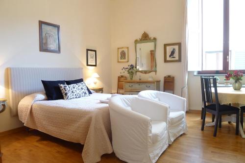 フィレンツェにあるAppartamento Vellutiniのベッドルーム1室(ベッド1台、テーブル、椅子付)